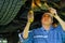 Asian automotive mechanic with blue uniform use wrench to fix the problem under the car in the garage