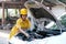 Asian automotive mechanic girl with yellow suit and helmet check the engine and system of the car during day time