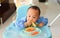 Asian baby boy 6 months old eating with Baby Led Weaning BLW method, Self-Feeding