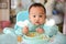 Asian baby boy 7 months old eating with Baby Led Weaning BLW method, Self-Feeding