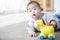 Asian baby boy playing horse toys on the floor.