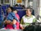 Asian baby girl leaning on her auntie`s shoulder with her grandmother sitting next to during a trip by train