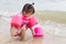 Asian baby girl playful on the beach background.