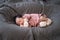 Asian baby infant wearing gloves and socks sleeping on gray bed. studio shot.