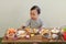 Asian baby playing with camping gear toy tools on the wooden table