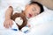 Asian baby sleep with teddy bear and saline on the bed in Hospital