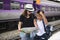 Asian backpack traveler woman with cute son using generic local map at a train station