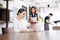 Asian barista man and Coffee waitress Asian woman is serving iced latte coffee for Caucasian businesswoman customer. She is