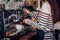 Asian barista woman making coffee cappuccino at cafe with machine at counter bar in eatery,Food and drink service concept