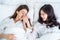 Asian beautiful lesbian couple lying down on bed and hug each other. Attractive romantic lgbt woman gay in pajamas sleeping in