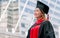 Asian beautiful long brown hair female student wearing graduation uniform with hat, looking away, smiling with happiness, pride