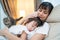 Asian beautiful loving mother hugging sleeping baby girl in her arms with gently. Parent holding small baby to rest on shoulder an