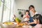 Asian beautiful mother cooking vegetable salad with two young daughter. Happy Family, attractive caring parent mom enjoy preparing