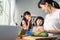 Asian beautiful mother cooking vegetable salad with two young daughter. Happy Family, attractive caring parent mom enjoy preparing