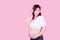 Asian beautiful pregnant woman stands relaxed and enjoys listening to music on headphones connected to the internet