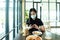 An Asian beautiful woman has to wear a blue mask and prepare to start breakfast in the coffee cafe with new normal and social-