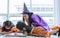 Asian beautiful woman or mother and two little sweet girls wearing witch costume with hats, playing and painting together with fun