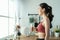 Asian beautiful woman in sportswear drink water after exercise at home. Young thirsty active sport girl takes a sips of clean