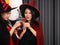 Asian beautiful women who wear vampire costume fashion and accessories cheers glasses of cocktail before drink in Happy Halloween