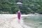 Asian beauty walking on beach during her vacation in tropical resort
