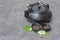 Asian black traditional teapot and teacups with green jasmine tea