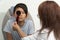 Asian boy in a consultation of an ophthalmologist woman