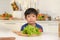 Asian boy feeling bored , unhappy to eat vegetables , health care concept