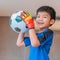 Asian boy a football goalkeeper wearing gloves and holding a soccer ball for youth sport concept