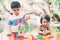 Asian boy and gril playing wooden block toy on table for creative and development with enjoy.