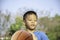 Asian boy holding a basketball ball Background blurry trees
