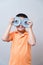 Asian boy joking gesture wearing fake glasses made with iron dum