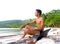 Asian boy with laptop on beach