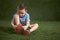 Asian boy learns to tying shoelaces on green grass background