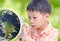 Asian boy looking at glowing globe by magnifying glass