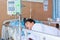 Asian boy lying on sickbed with infusion pump intravenous IV drip.