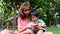 An asian boy and mother are playing funny game on smart phone at the park