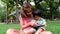 An asian boy and mother are playing funny game on tablet at the park