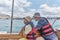 An Asian boy and older man, his grandfather trip on pleasure boat on the sea.