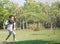 Asian boy playing airplane toy in park outdoors.