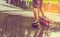 asian boy playing scooter on wet ground .