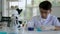 Asian boy researches blue liquid in chemistry lesson at laboratory