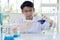 Asian boy researches blue liquid in chemistry lesson at laboratory