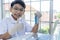 Asian boy researches blue liquid and use laptop in laboratory