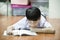 Asian boy rest on the floor doing homework