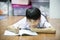 Asian boy rest on the floor doing homework