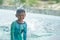 Asian boy in swimming suit in swimming pool smile with water splashing in summer holiday