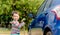 Asian boy washing blue car by green water sprayer