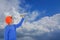 Asian boy, wearing glasses, orange hat and long blue shirt. Throwing a paper airplane