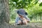 Asian boy wearing a hat in a forest exploration suit Use a magnifying glass to survey the tree area