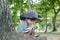 Asian boy wearing a hat in a forest exploration suit Use a magnifying glass to survey the tree area